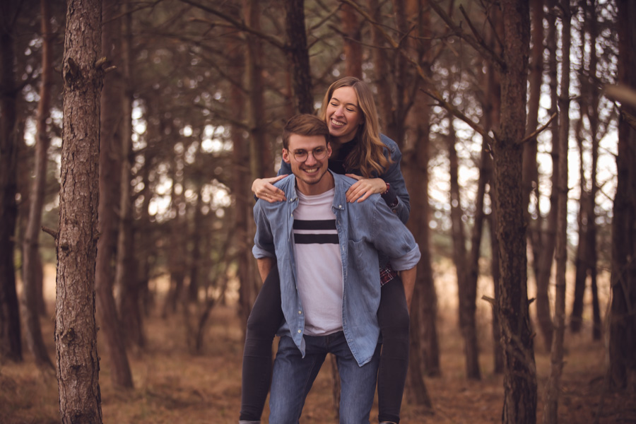 Verliebtes Paar huckepack beim Fotoshooting im Wald